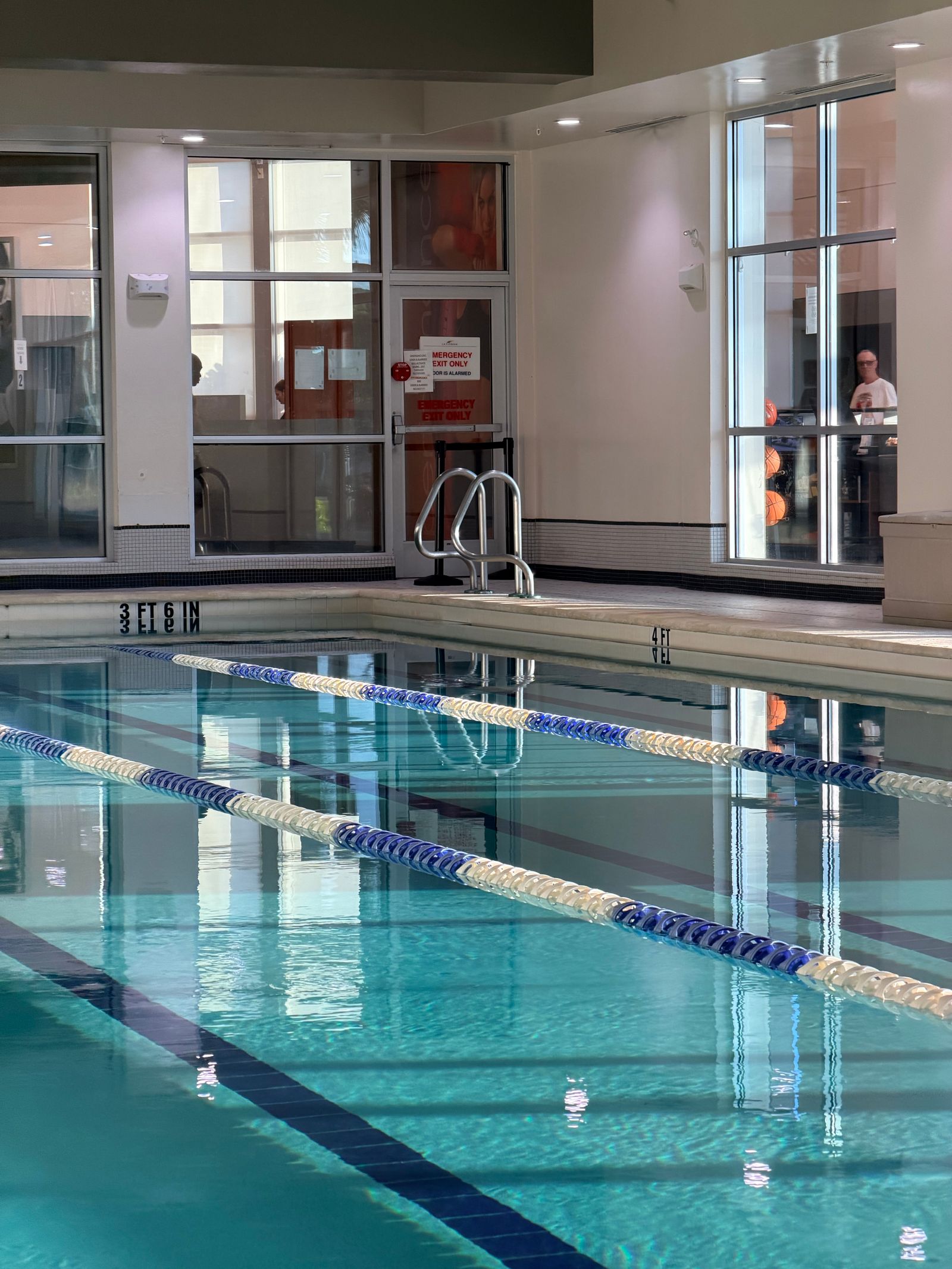 Calm water and blue lane ropes in an indoor pool